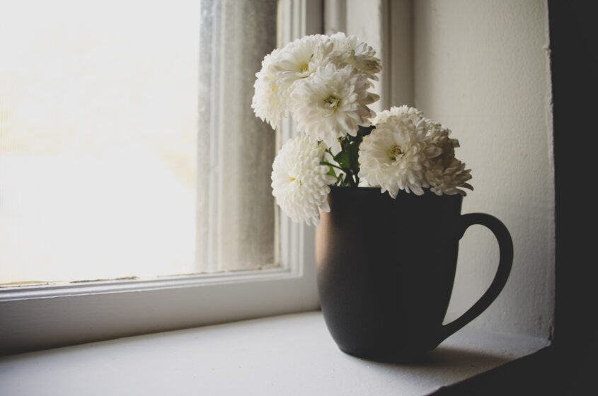 kamienny parapet na którym stoi wazon z kwiatami